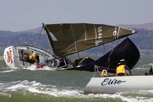 Diese Yacht kentert unter Spinnaker nach Luv. Sie wird sich gleich wieder aufrichten, aber dabei geht ein Mann über Bord.