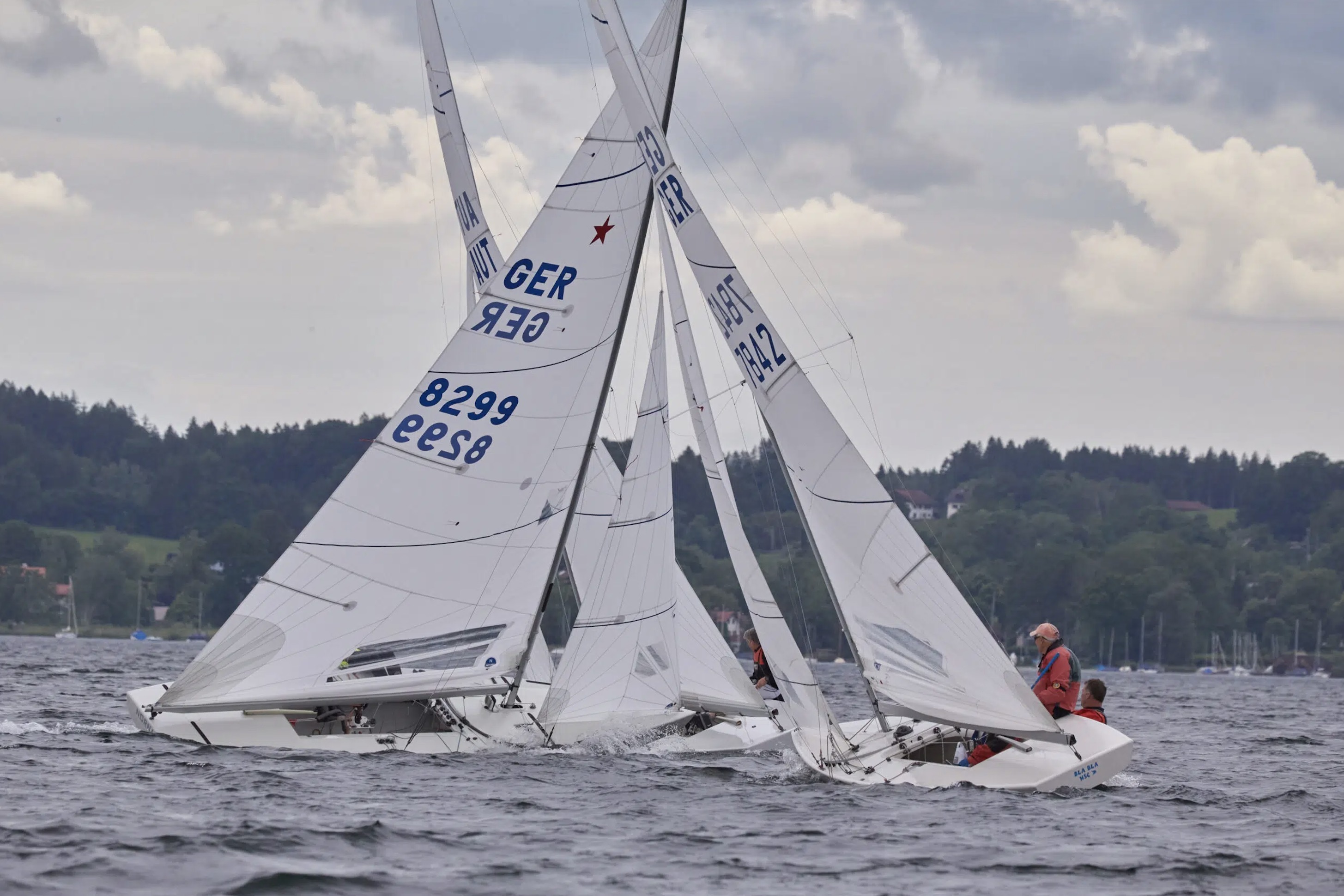 Kreuzende Starboote. GER 8299 (links) segelt auf Steuerbordbug vor GER 7842 (rechts) her, der  auf Backbordbug läuft.
