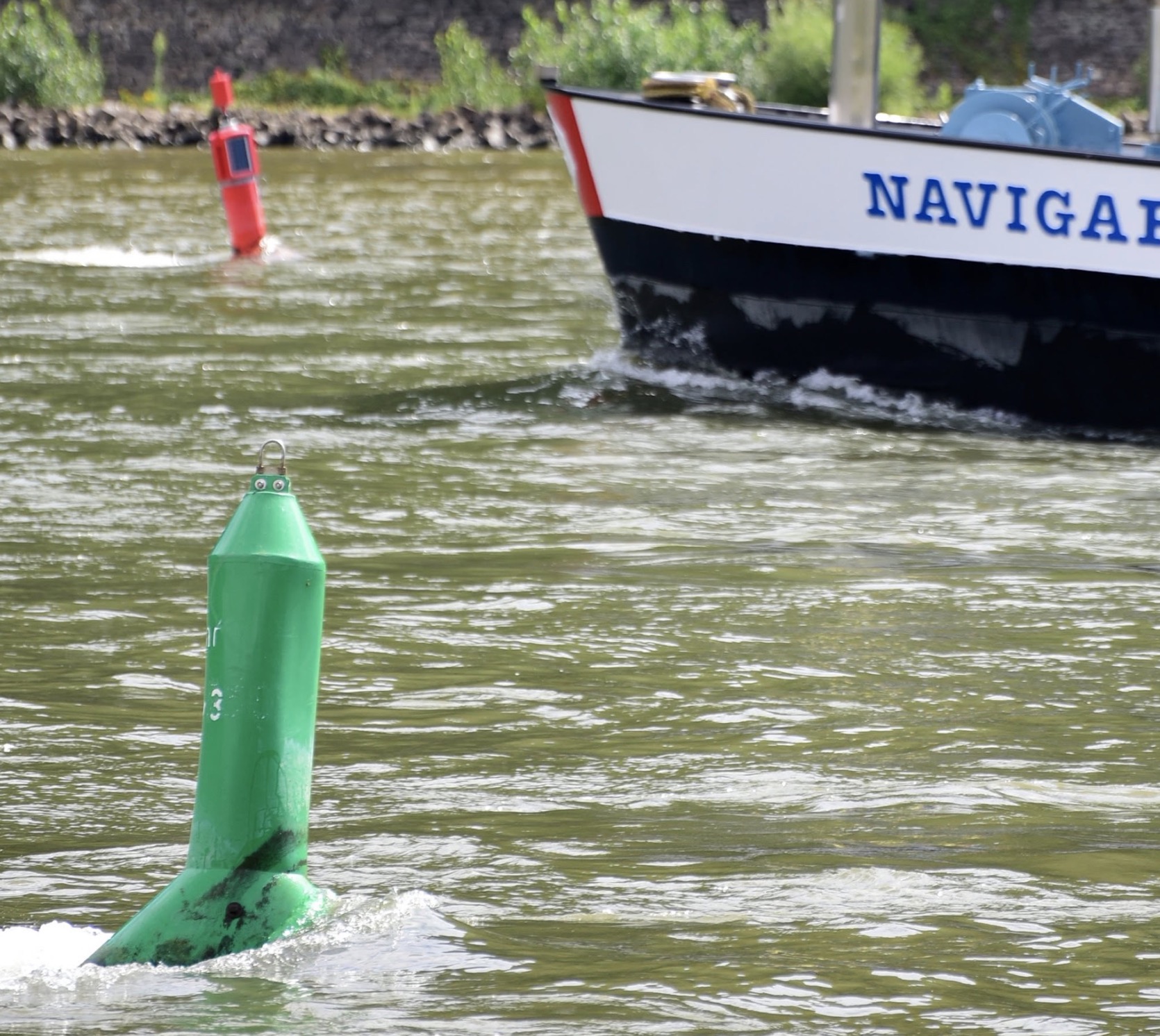 Fahrwassertonnen im Rhein. Die Seite mit den roten Tonnen ist die Backbordseite des Fahrwassers, die Seite mit den grünen Tonnen die Steuerbordseite. 